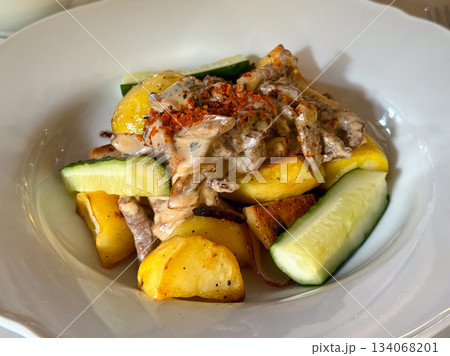 Lunch with roasted potatoes, mushrooms, and sauce. Everyday dining, comfort, and satisfaction captured in warm tones and gentle light. Lunch with roasted potatoes, mushrooms, and sauce. Everyday dining, comfort, and satisfaction captured in warm tones and gentle light. 134068201