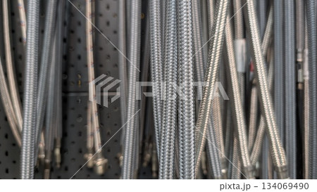 Reflective metallic coils neatly hung in industrial workspace Reflective metallic coils neatly hung in industrial workspace 134069490