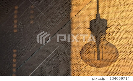 warm glow ambiance, cozy workshop setting with hanging bulb casting intricate shadows on wooden warm glow ambiance, cozy workshop setting with hanging bulb casting intricate shadows on wooden 134069714