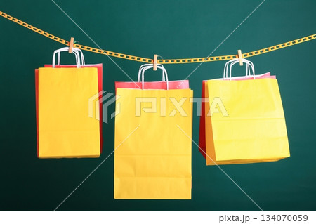 Shopping yellow gift bags on green background 134070059