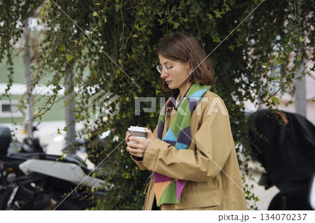 Calm outdoor setting featuring woman enjoying hot beverage Calm outdoor setting featuring woman enjoying hot beverage 134070237