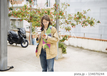 Woman in comfortable attire appreciating fresh morning air and electronics 134070244