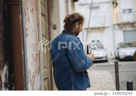 Urban man pauses, Individual in doorway takes thoughtful rest Urban man pauses, Individual in doorway takes thoughtful rest 134070245