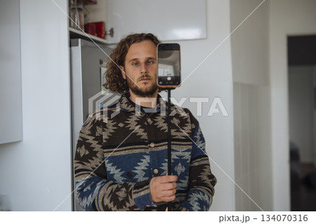 Person setting up filming device in small home space carefully Person setting up filming device in small home space carefully 134070316