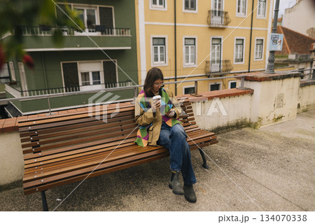 Solo traveler relaxing on park bench with colorful outfit Solo traveler relaxing on park bench with colorful outfit 134070338