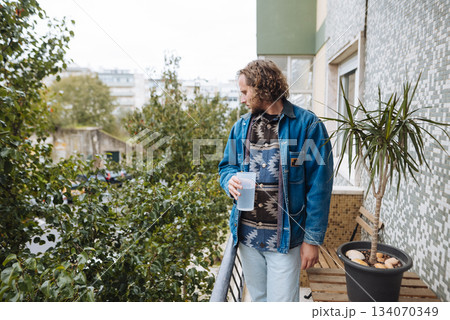 caucasian man freelance designer on balcony with coffee 134070349