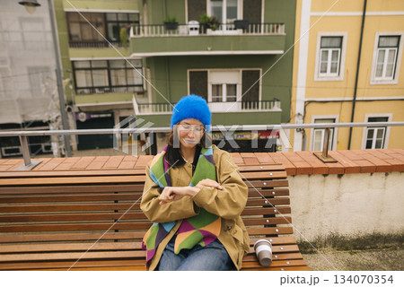 Studentstyle woman sitting on rooftop with coffee in city 134070354