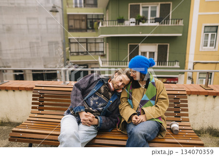 Two individuals enjoying calm pause after leisurely stroll through downtown 134070359