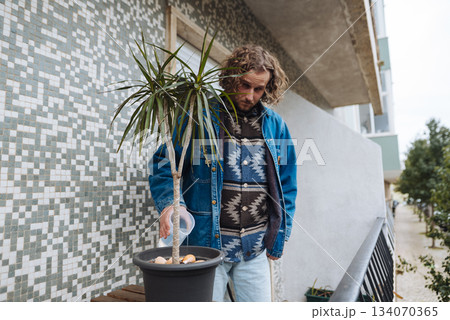 Person tending potted greens outdoors in city environment with style Person tending potted greens outdoors in city environment with style 134070365