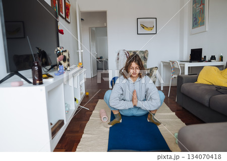 white female smiling in seated meditation, approachable wellness coach white female smiling in seated meditation, approachable wellness coach 134070418