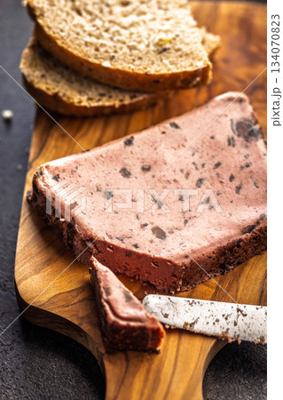 Liver pate with cranberries on wooden cutting board. 134070823