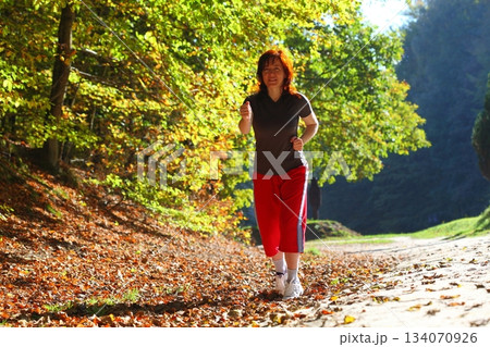 Woman walking cross country trail in autumn forest Woman walking cross country trail in autumn forest 134070926