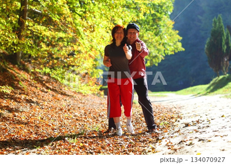 Woman and man walking cross country trail in autumn forest Woman and man walking cross country trail in autumn forest 134070927