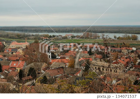 Sremski Karlovci rooftops with church tower and river landscape stretching into the distance. The scene expresses culture and old-town charm Sremski Karlovci rooftops with church tower and river landscape stretching into the distance. The scene expresses culture and old-town charm 134071537