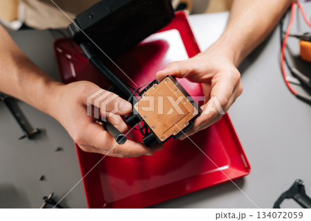 Close-up of technician hands installing liquid cooling system CPU block on computer hardware, performing maintenance, assembly, upgrade of high-performance pc components for better cooling. Close-up of technician hands installing liquid cooling system CPU block on computer hardware, performing maintenance, assembly, upgrade of high-performance pc components for better cooling. 134072059