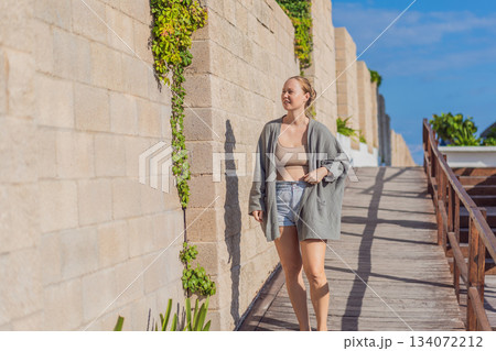 Woman enjoying peaceful time at the beach, relaxing on the sand with ocean views and warm sunlight. Summer leisure, wellbeing and travel concept, representing freedom, calmness and mindful coastal Woman enjoying peaceful time at the beach, relaxing on the sand with ocean views and warm sunlight. Summer leisure, wellbeing and travel concept, representing freedom, calmness and mindful coastal 134072212