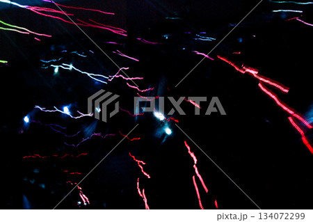 Bright, colorful light trails and flashes swirl across dark backdrop, vibrant visual effect. Essence of lively night event. Dynamic movement of lights suggests festive atmosphere, energy celebration Bright, colorful light trails and flashes swirl across dark backdrop, vibrant visual effect. Essence of lively night event. Dynamic movement of lights suggests festive atmosphere, energy celebration 134072299