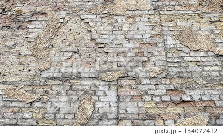 Textured background of an old, weathered brick wall with patches of rough, crumbling plaster Textured background of an old, weathered brick wall with patches of rough, crumbling plaster 134072412