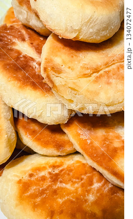 Close up of a pile of traditional homemade golden brown baked or fried pies 134072477