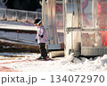 A girl on skis stands on a carpet ski lift in a glass tunel 134072970