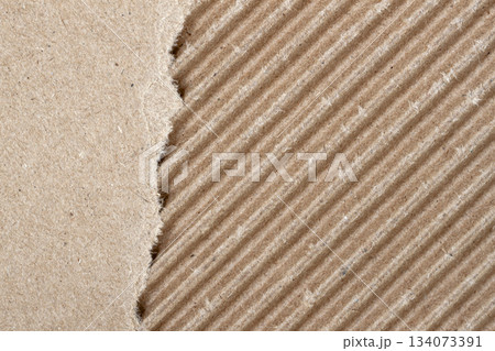 Torn corrugated cardboard with diagonal lines. Macro view of ripped craft paper, corrugated cardboard with diagonal faded lines, recycled texture. Natural background for scrapbooking, handmade collage Torn corrugated cardboard with diagonal lines. Macro view of ripped craft paper, corrugated cardboard with diagonal faded lines, recycled texture. Natural background for scrapbooking, handmade collage 134073391