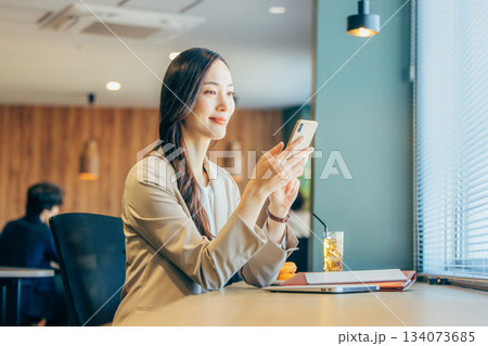 コワーキングスペースでスマホを見るビジネスウーマン コワーキングスペースでスマホを見るビジネスウーマン 134073685