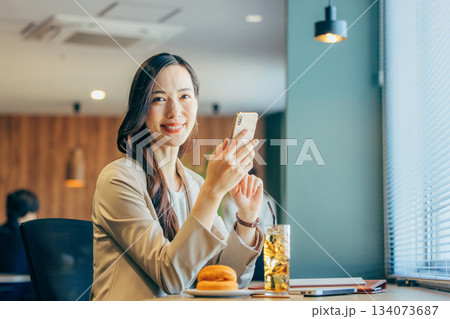 コワーキングスペースでスマホを見るビジネスウーマン 134073687