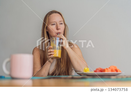 Woman enjoying a peaceful breakfast at the table in a bright home interior, starting her morning with calm energy. Healthy lifestyle, morning routine and wellbeing concept, representing self-care Woman enjoying a peaceful breakfast at the table in a bright home interior, starting her morning with calm energy. Healthy lifestyle, morning routine and wellbeing concept, representing self-care 134073758