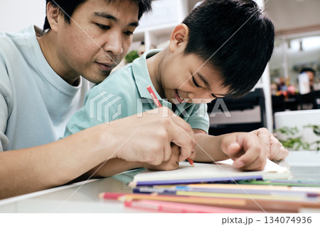 Father guiding child in drawing at home creativity, learning, and supportive family interaction in warm environment perfect for education and parenting themes Father guiding child in drawing at home creativity, learning, and supportive family interaction in warm environment perfect for education and parenting themes 134074936