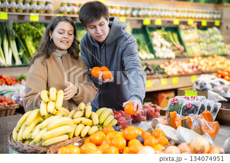 Happy married couple buying various fruits in grocery supermarket Happy married couple buying various fruits in grocery supermarket 134074951