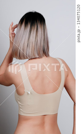 Rear view of a woman in nude underwear with wet hair, showing her back  134075120