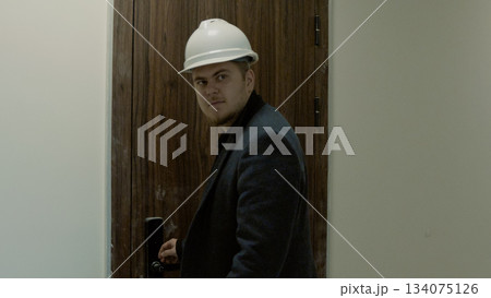 Male engineer or architect walking through the incomplete building interior Male engineer or architect walking through the incomplete building interior 134075126