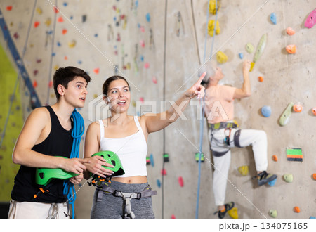 Confident male climbing instructor and his female trainee getting ready for training 134075165