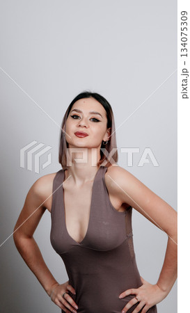 Woman in a dark pajama shirt posing with a thoughtful expression and hand Woman in a dark pajama shirt posing with a thoughtful expression and hand 134075309
