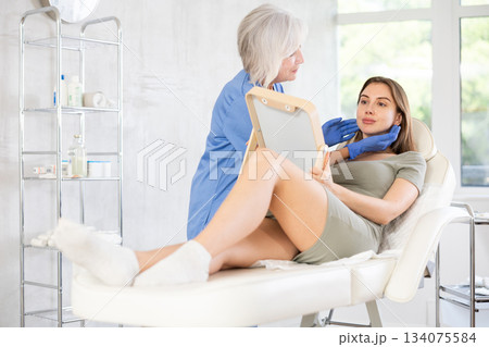 Cosmetologist with gloves preparing patient to skin care procedure in spa salon. 134075584