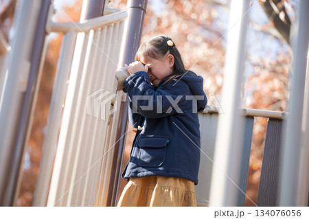 秋の公園で遊具で遊ぶ子供　冬の子どもお出かけやレジャーのイメージ　望遠鏡でのぞく 134076056