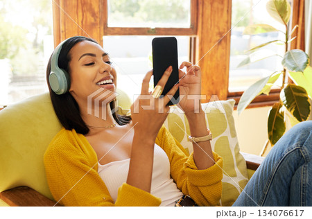Woman, smartphone and headphones, smile at social media and communication, technology and listening to music. Online chat, happy female relax at home with app and podcast, games and scroll internet Woman, smartphone and headphones, smile at social media and communication, technology and listening to music. Online chat, happy female relax at home with app and podcast, games and scroll internet 134076617
