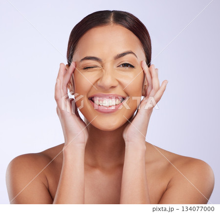 Woman portrait, beauty wink and skincare in a studio with happiness and smile from dermatology. Skin glow, facial and cosmetics of a young female model feeling happy from self care and face wellness Woman portrait, beauty wink and skincare in a studio with happiness and smile from dermatology. Skin glow, facial and cosmetics of a young female model feeling happy from self care and face wellness 134077000