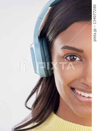 Portrait, headphones and half with a woman in studio on a gray background listening to music. Face, happy and smile with an attractive young female streaming audio using a subscription service 134077280