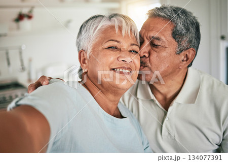 Selfie portrait, kiss and senior happy couple love, home romance and bonding on memory photo. Romantic marriage partner, face and elderly man, old woman or people smile on retirement time together 134077391