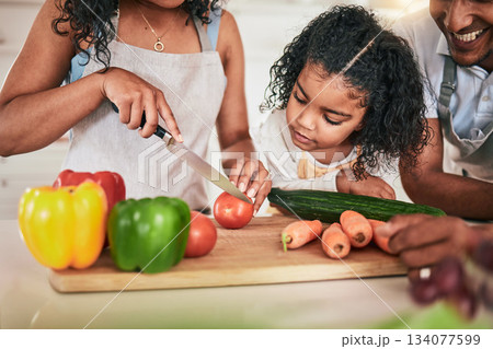 Family, cutting vegetables and cooking together, learning chef skill with parents and child in kitchen. Nutrition, healthy food and organic with people teaching and learn to cook at home with bonding Family, cutting vegetables and cooking together, learning chef skill with parents and child in kitchen. Nutrition, healthy food and organic with people teaching and learn to cook at home with bonding 134077599