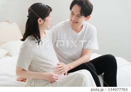 ベッドでくつろいでいる妊婦と夫 ライフスタイルイメージ ベッドでくつろいでいる妊婦と夫 ライフスタイルイメージ 134077763