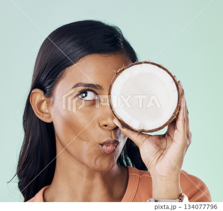 Beauty, face or wellness woman with coconut for natural skincare glow, organic cosmetics or eco friendly makeup. Pucker, fruit nutrition benefits or person with clean healthy food on green background Beauty, face or wellness woman with coconut for natural skincare glow, organic cosmetics or eco friendly makeup. Pucker, fruit nutrition benefits or person with clean healthy food on green background 134077796