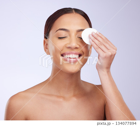 Beauty, skincare and cotton swab with a woman in studio on a gray background for natural treatment. Facial, wellness and anti aging with an attractive young female exfoliating her face or skin 134077894