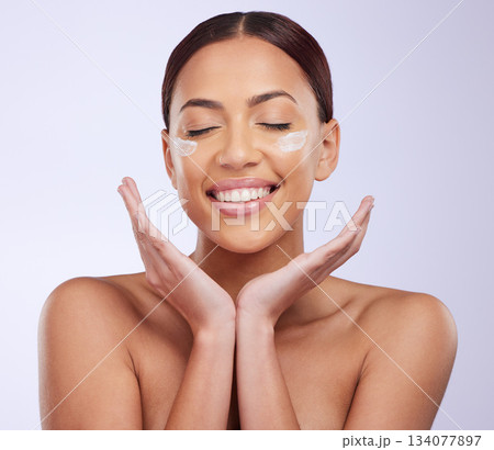 Face cream, beauty and woman in studio for skincare, treatment and dermatology on purple background. Facial, lotion and sunscreen for happy lady model relax with spf, moisturiser or skin routine 134077897