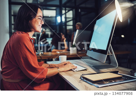 Night, business and woman typing, smile and focus on data analysis, email and project deadline. Female employee, creative and worker with a computer, screen and working late for digital planning 134077908