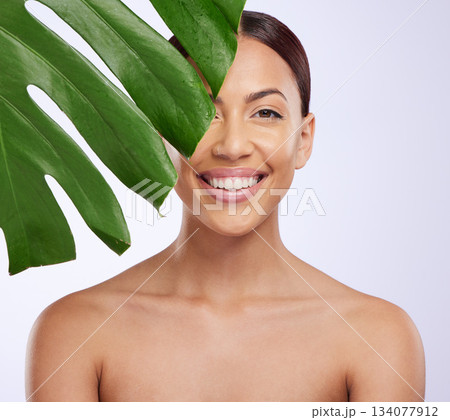 Portrait, leaf and woman in studio for skincare, dermatology and cosmetic on purple background. Beauty, face and girl model relax, smile and happy with glowing skin, cosmetology or monstera treatment Portrait, leaf and woman in studio for skincare, dermatology and cosmetic on purple background. Beauty, face and girl model relax, smile and happy with glowing skin, cosmetology or monstera treatment 134077912