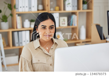 Business, digital or Indian woman typing on computer working on email or online project research. Technology, office feedback or girl journalist writing blog reports or internet articles with focus 134078373
