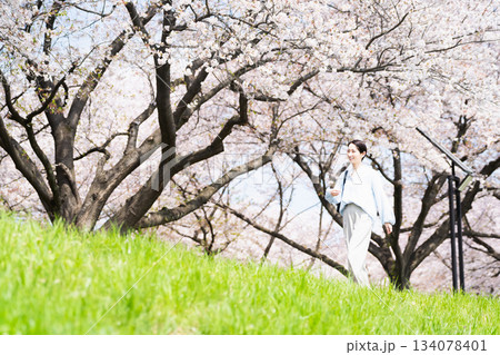 桜並木を散歩する若い女性　ライフスタイルイメージ 134078401