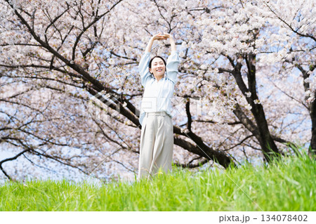 桜の木の下でストレッチをする若い女性 ライフスタイルイメージ 桜の木の下でストレッチをする若い女性 ライフスタイルイメージ 134078402